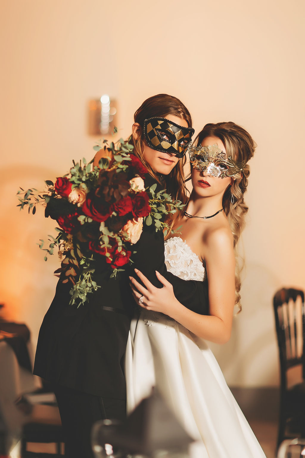 Bride and groom wearing masquerade masks
